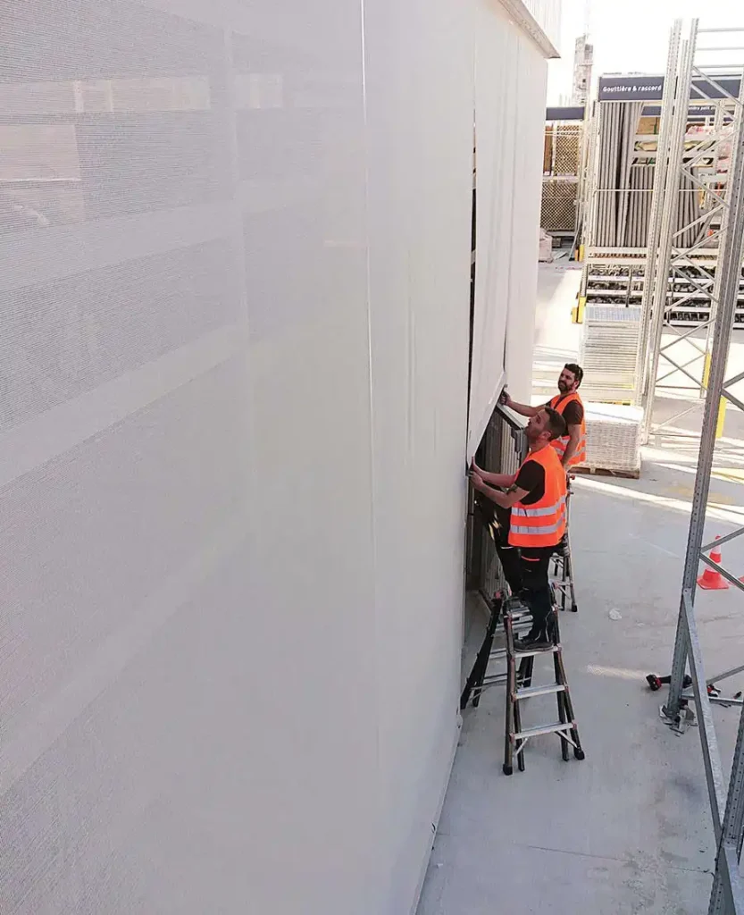 _Deux techniciens installent une façade textile à Leroy merlin