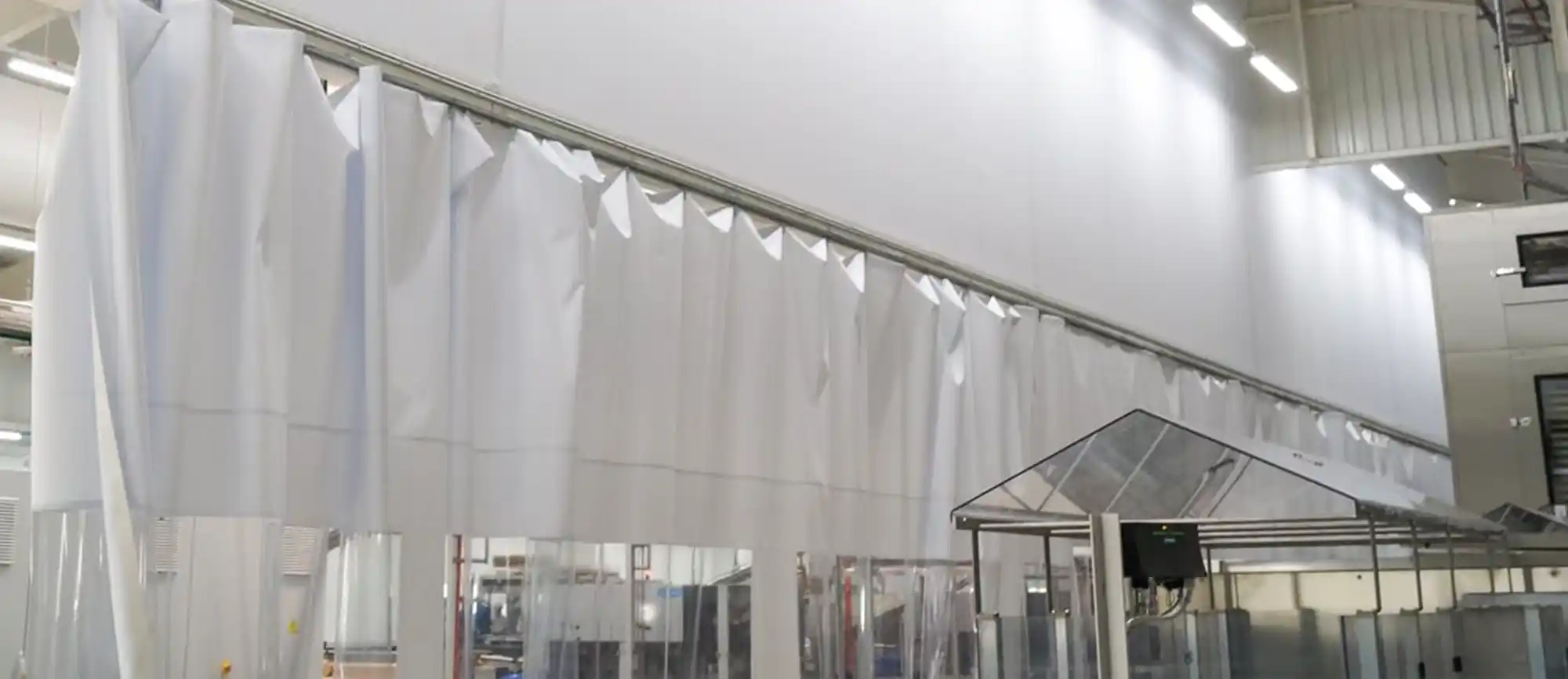 Grand rideau en bache blanche pour séparer les ateliers d'une industrie