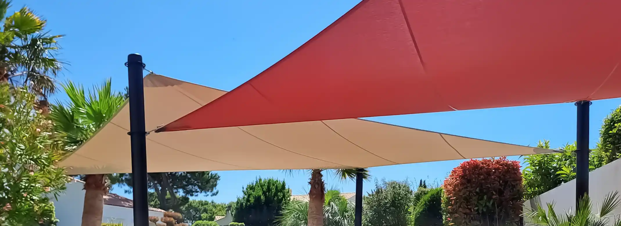 _Voiles d'ombrages beige et rouge qui couvre la terrasse d'un jardin