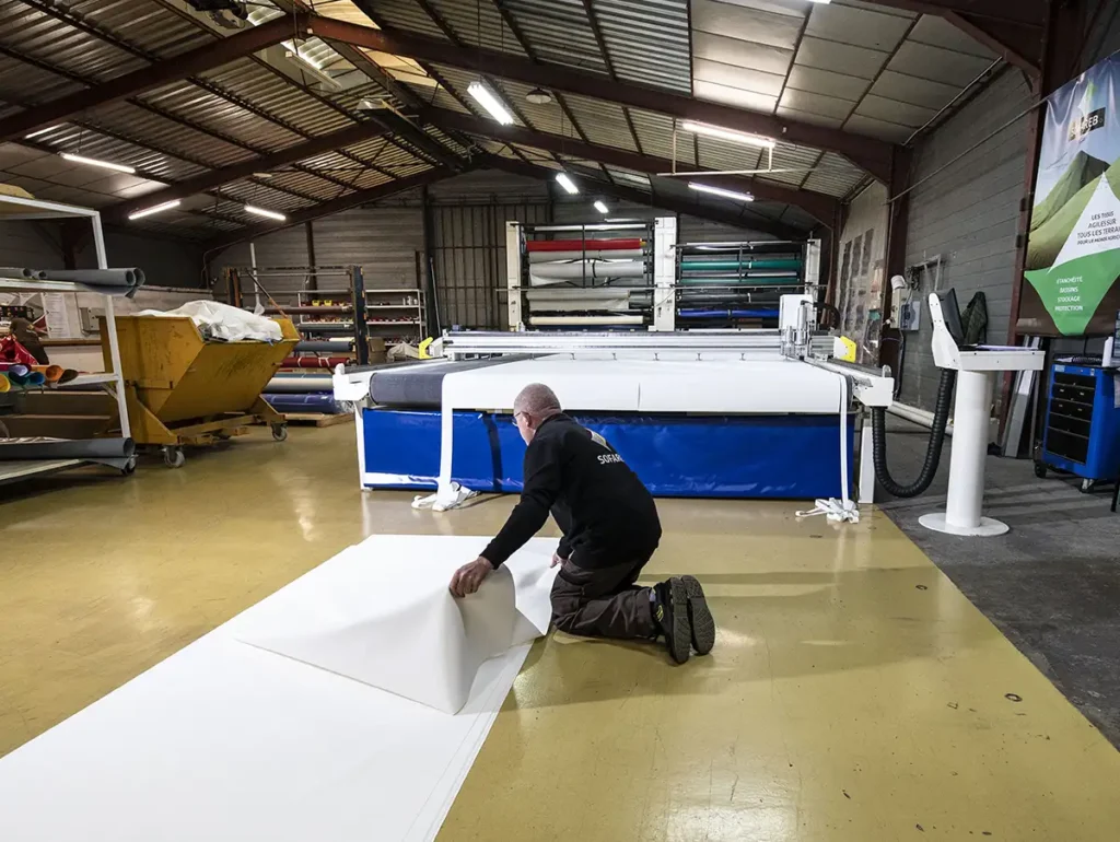 3-Salariés sofareb entrain de découper du tissu technique dans les ateliers